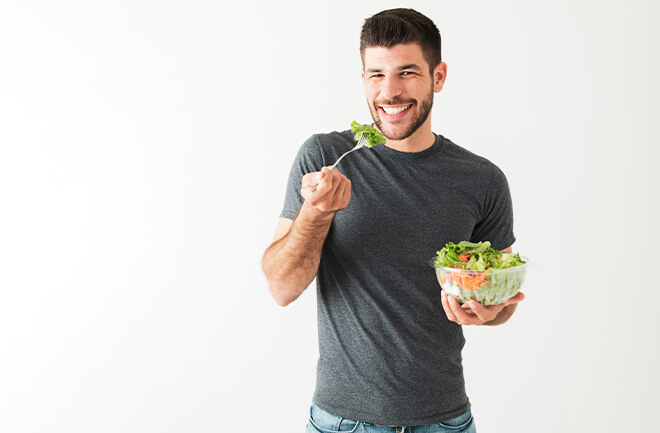 homem consumindo salada evitando alimentos que te deixam inchado