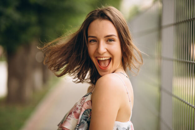 menina com sorriso aberto jogando os cabelos