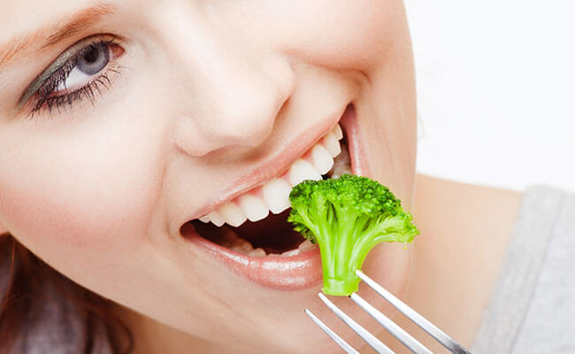 mulher comendo brócolis