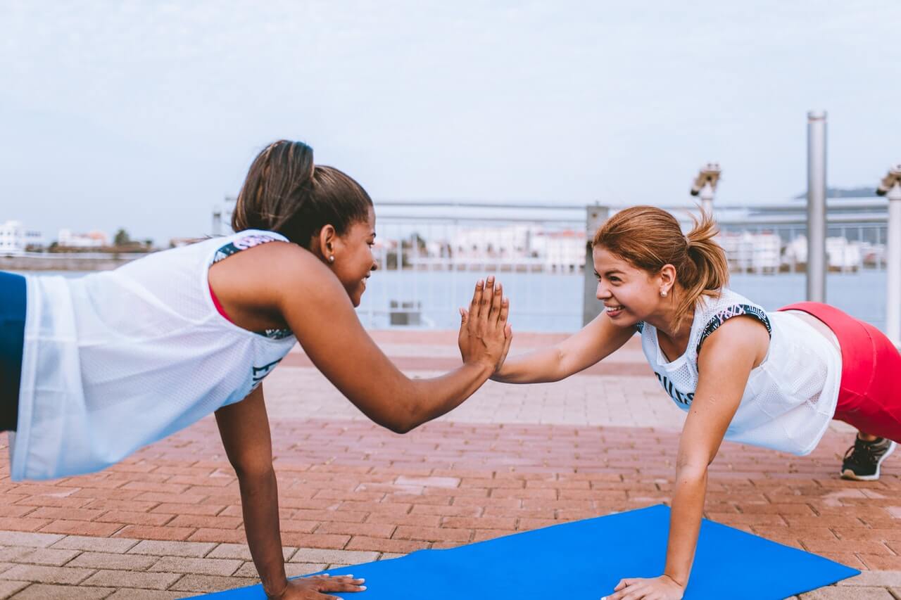 Duas mulheres fazendo exercícios físicos ao ar livre