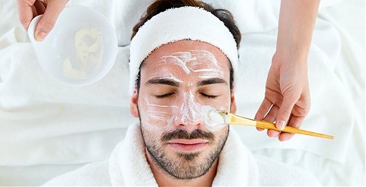 Homem aplicando protetor solar no rosto após uma limpeza de pele masculina
