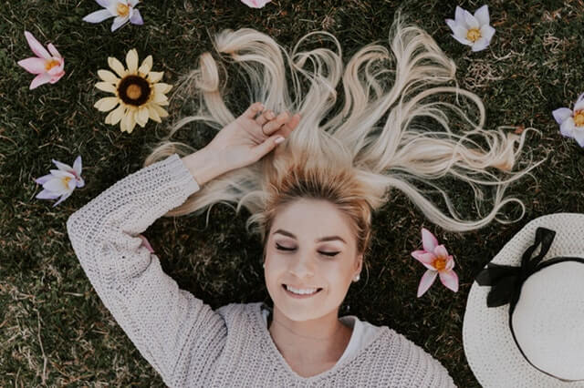 Mulher deitada na grama sorrindo