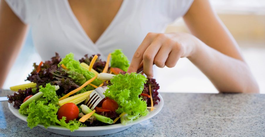 Pessoa comendo em um prato com verduras e legumes