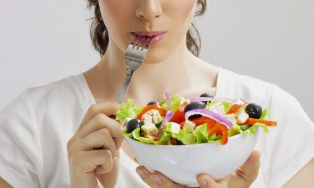 mulher comendo salada de folhas para uma reeducação alimentar